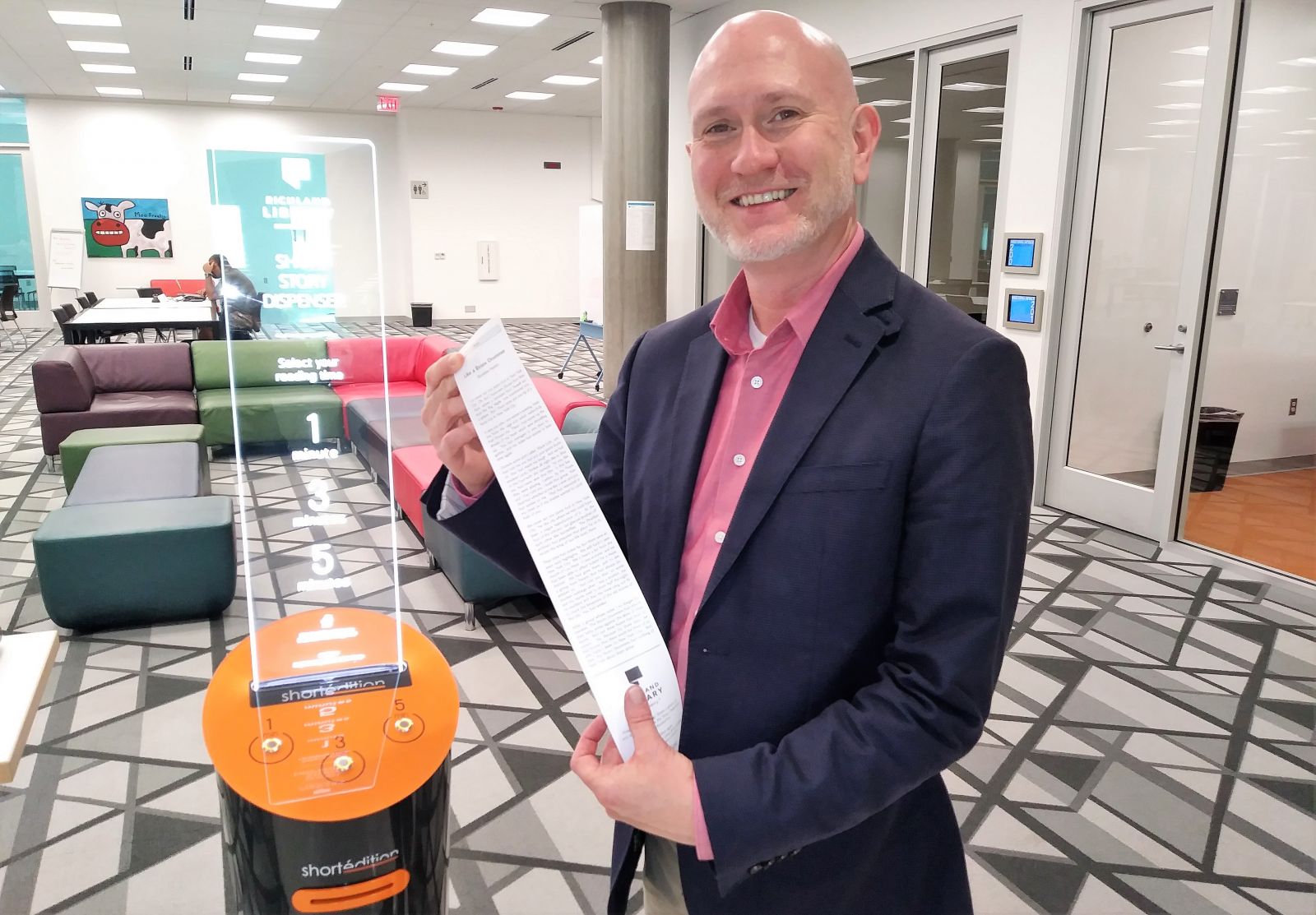 Tony Tallent, chief program and innovation officer at Richland Library, with the spoils from a short story dispenser. (Photo/Travis Boland)