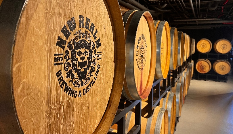All of the brews at New Realm’s Greenville site will be aged in wooden barrels, like these that first saw service as whisky barrels. (Photo/Ross Norton)|New Realm Brewing Co.’s leadership team includes cofounders Carey Falcone, CEO, and Mitch Steele, chief operating officer and brewmaster. (Photo/Ross Norton)|The Old Cigar Warehouse renovation including preserving the old signage. Although New Realm Brewing Co. will sell cigars in its speakeasy as a nod to the building’s history, they won’t go for a nickel as the old sign advertises. (Photo/Ross Norton)|CEO Falcone said the company was committed to maintain the historical integrity of the Old Cigar Warehouse. (Photo/Ross Norton)