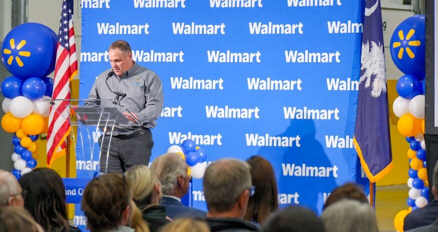 Walmart Distribution General Manager James Bright speaks during dedication ceremonies for the new facility. (Photo/Walmart U.S.)|Walmart associates cut the ribbon to open the new 725,000-square-foot perishable distribution center that will supply 180 stores and create 600 jobs. (Photo/Walmart U.S.)
