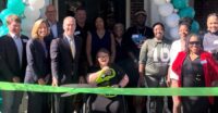 Katilyn Lengel puts the giant scissors to a ribbon during a dedication ceremony for Gateway at the Green. (Photo/Greenville Housing Fund)